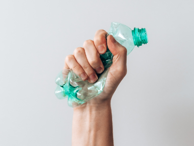 Plastová láhev mačkaná v pěsti